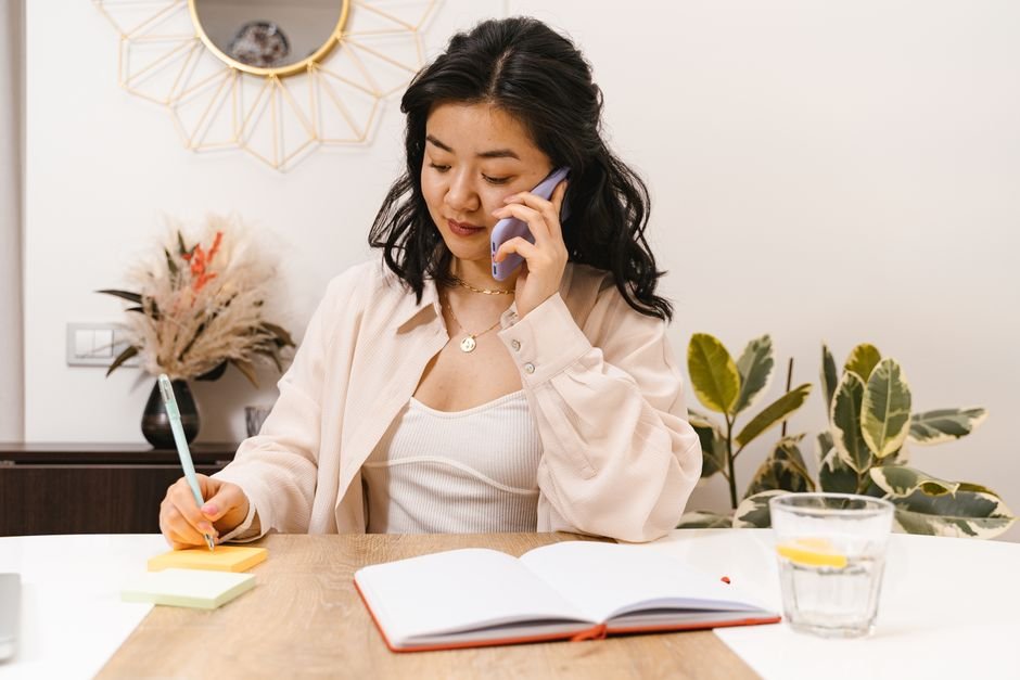 Person making a phone call while taking notes